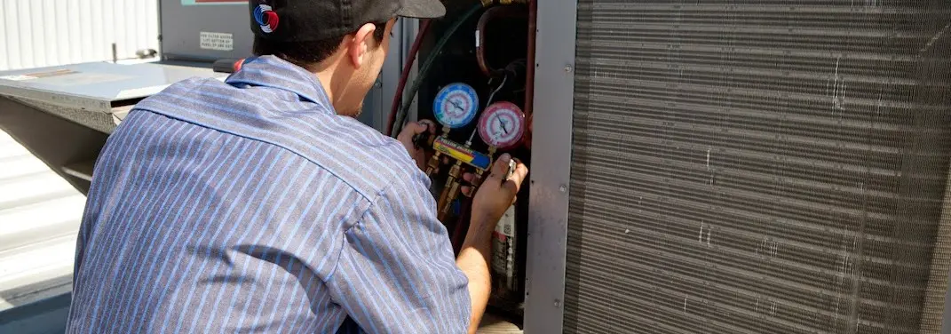 HVAC technician servicing a condenser unit in West Vero Corridor