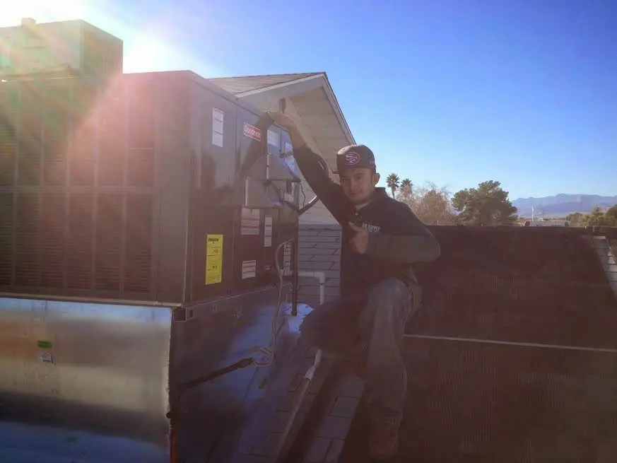 HVAC technician performing AC Tune-Up on a rooftop unit in West Vero Corridor